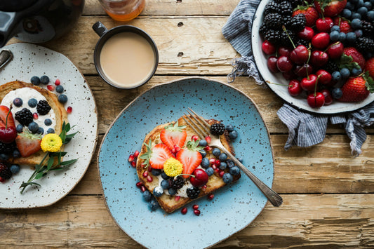 strawberries and blueberries on toast at a breakfast table